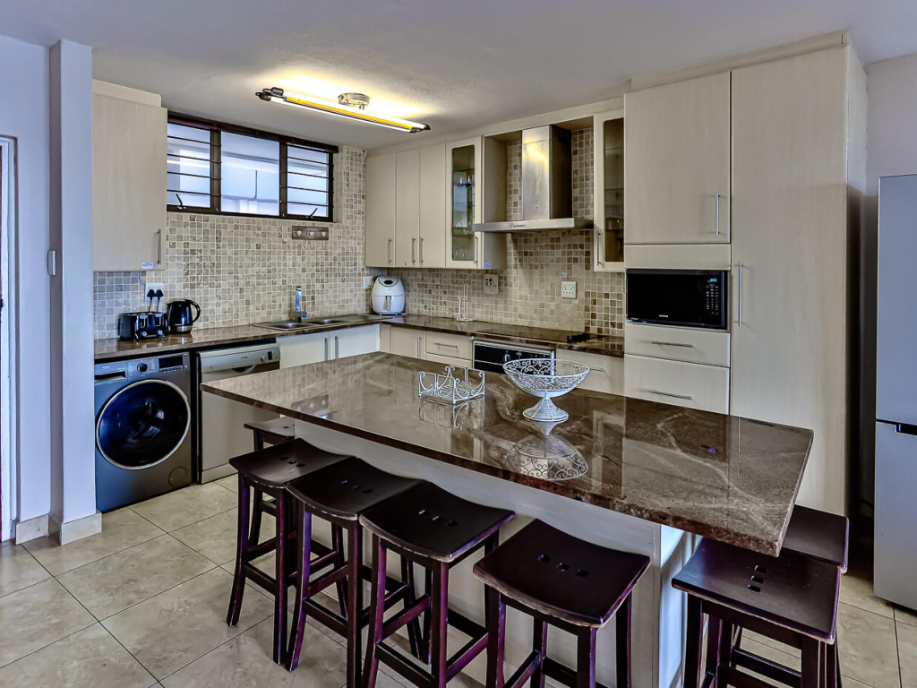 Kitchen with island and bar stools in a Cyberview Letting apartment