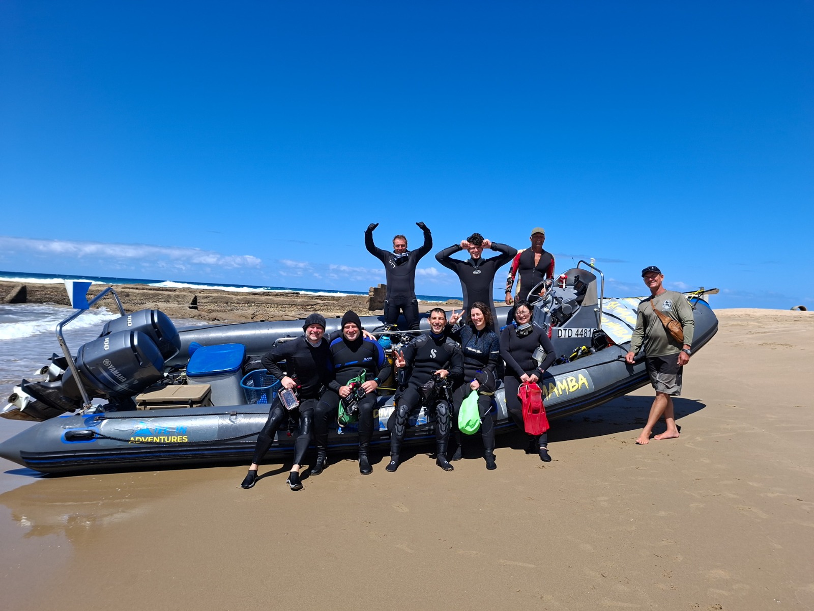 Dive group boarding the boat at the beach launch with Dive In Adventure Tours
